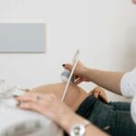 Lekarz wykonuje USG ciężarnej kobiecie w gabinecie