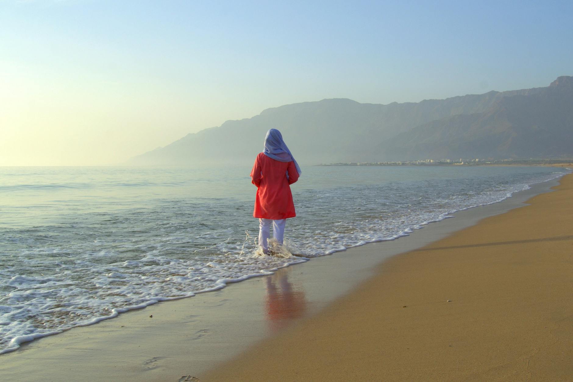 Para spacerująca brzegiem morza trzymająca się za ręce